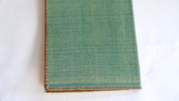 מחברת שורה מחופה בבד רך ירוק ובחזית ריקמה בכתום לסיומת